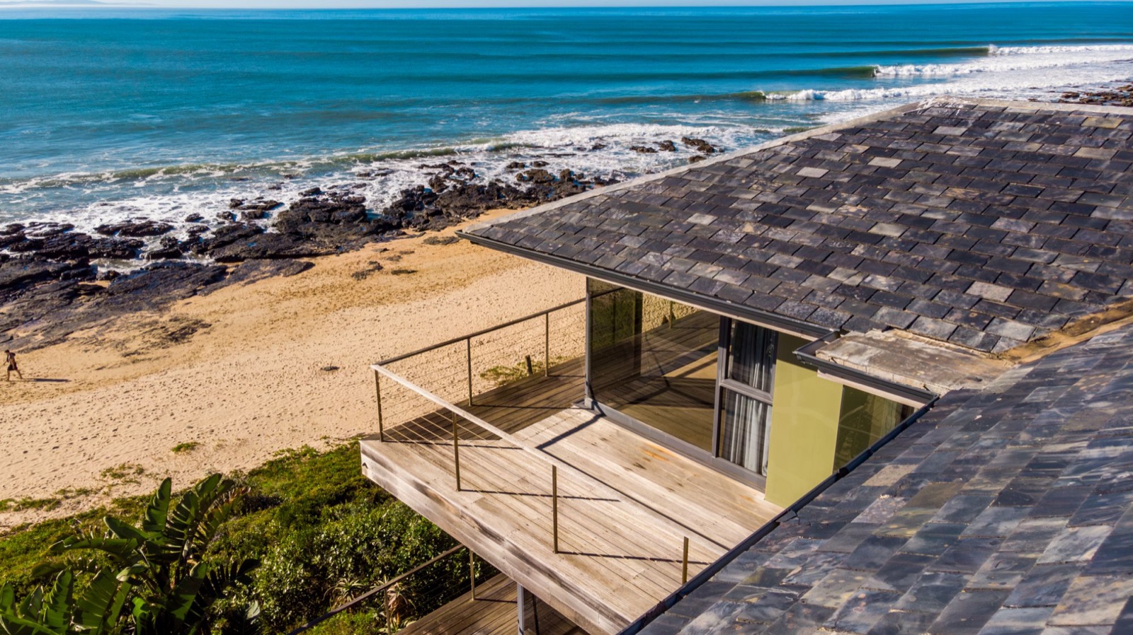 The upper deck of the Supertubes house looking straight down onto the beach and the waves breaking along the point