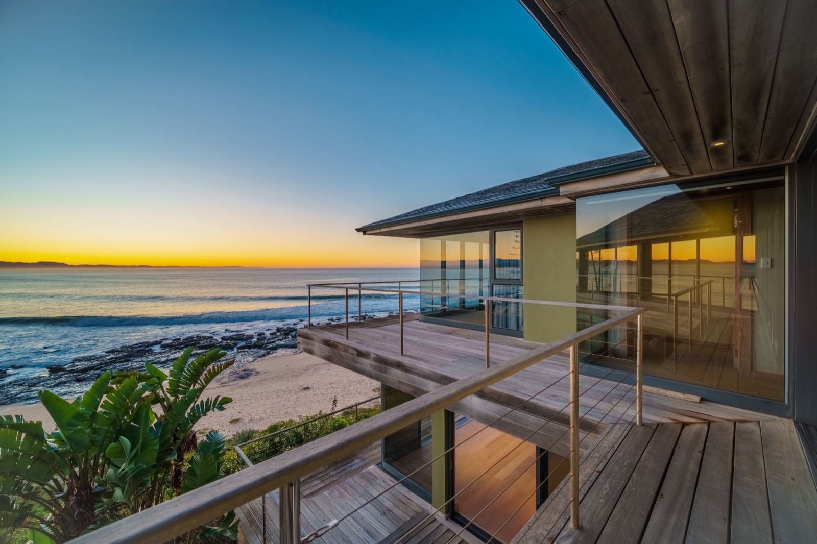Sunset from the timber deck of the Supertubes house, with the sea and the Jeffreys Bay coastline in view